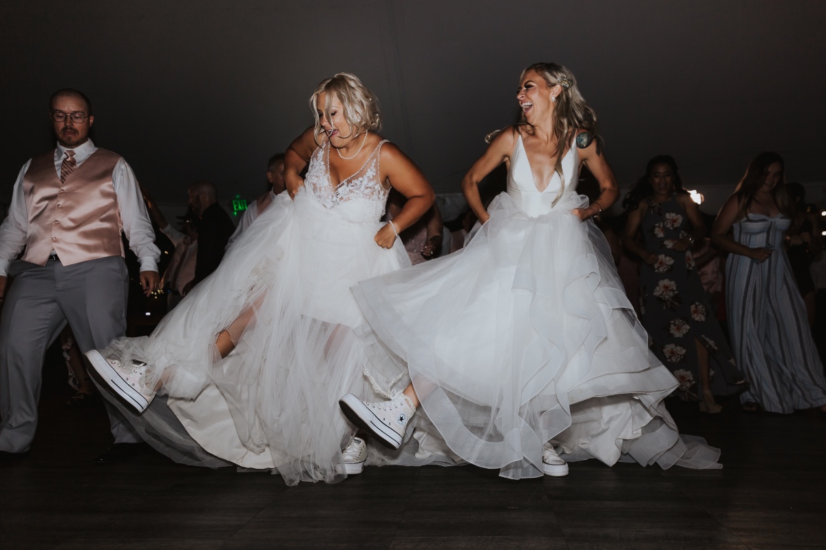 Brides dancing at wedding in matching wedding converse
