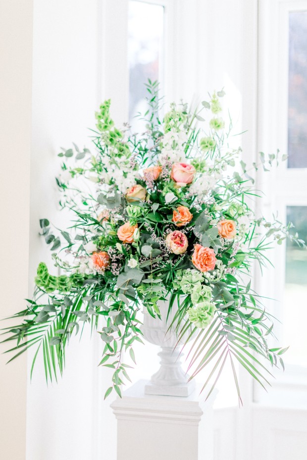Elegant floral arrangement in a white urn, great for weddings