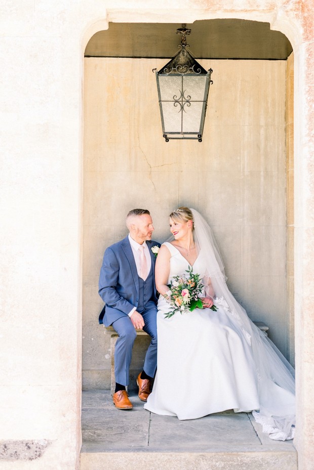 Elegant bride and groom seated during their wedding day, smiling together