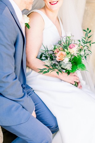 Bride and groom smiling together at a wedding with beautiful flowers