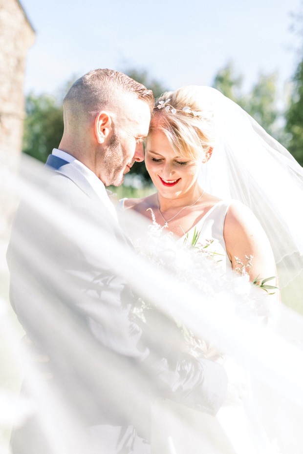 Bride and groom on their wedding day with veil in the wind