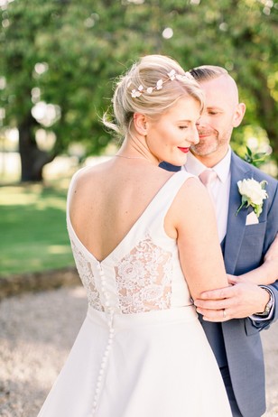 Bride and groom embrace on their wedding day, outdoor ceremony