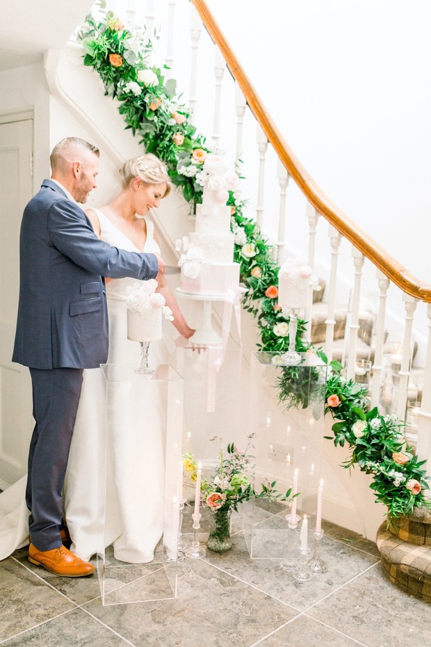 Bride and groom cutting wedding cake at a beautiful ceremony