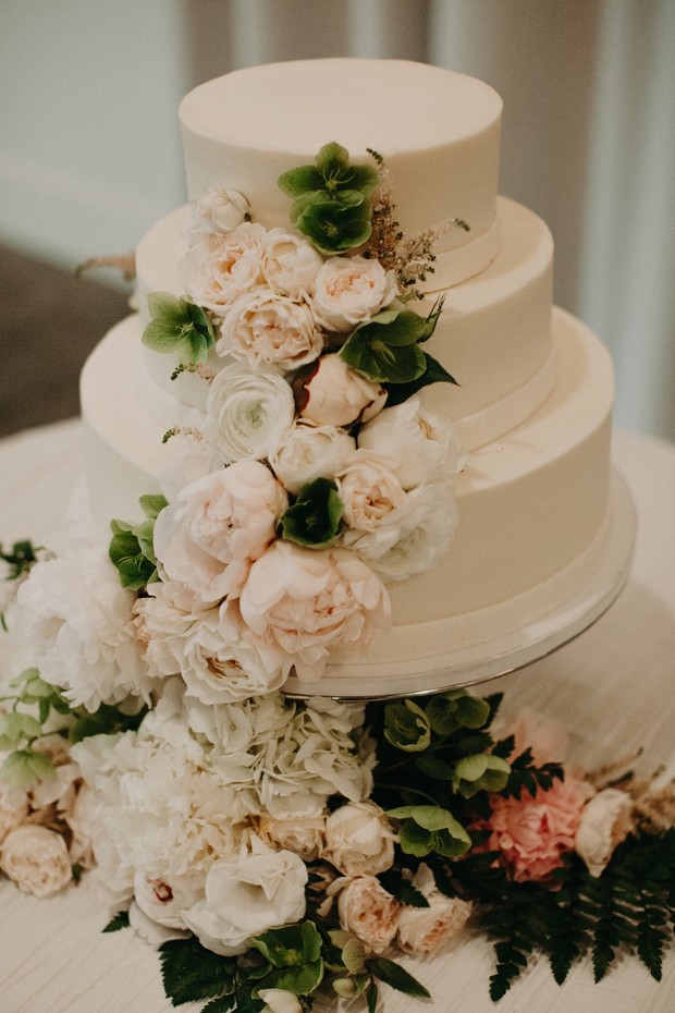 white wedding cake decorated with peonies