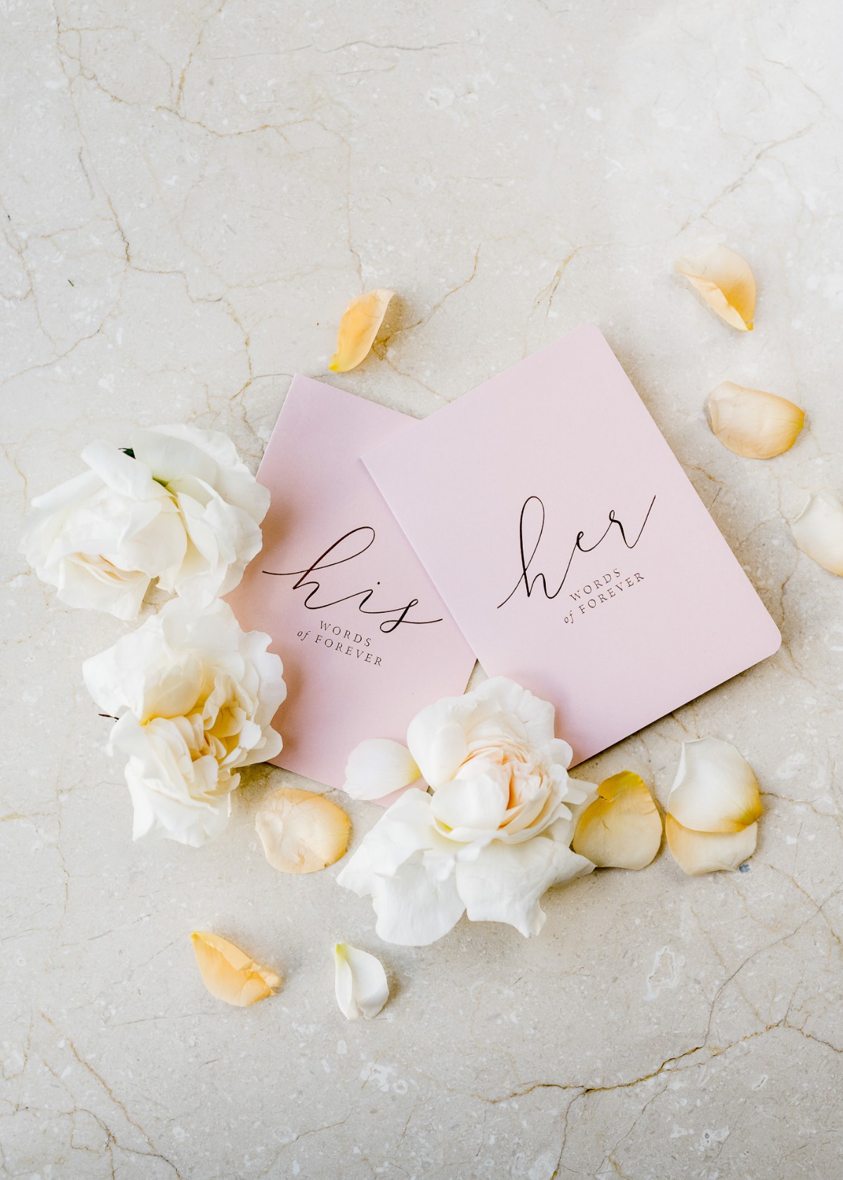 Pink his and her cards with roses and petals on marble background