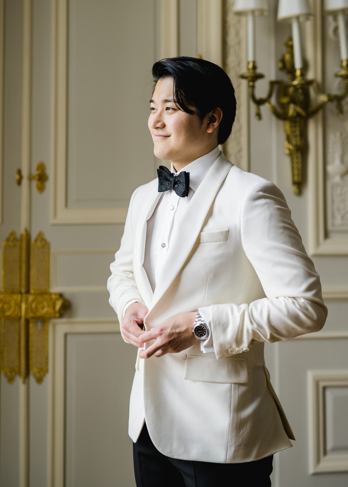 Stylish man in a white tuxedo, preparing for a special occasion