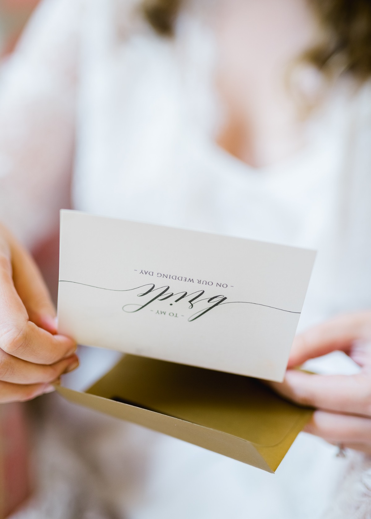 Bride opening a wedding day card with a beautiful message