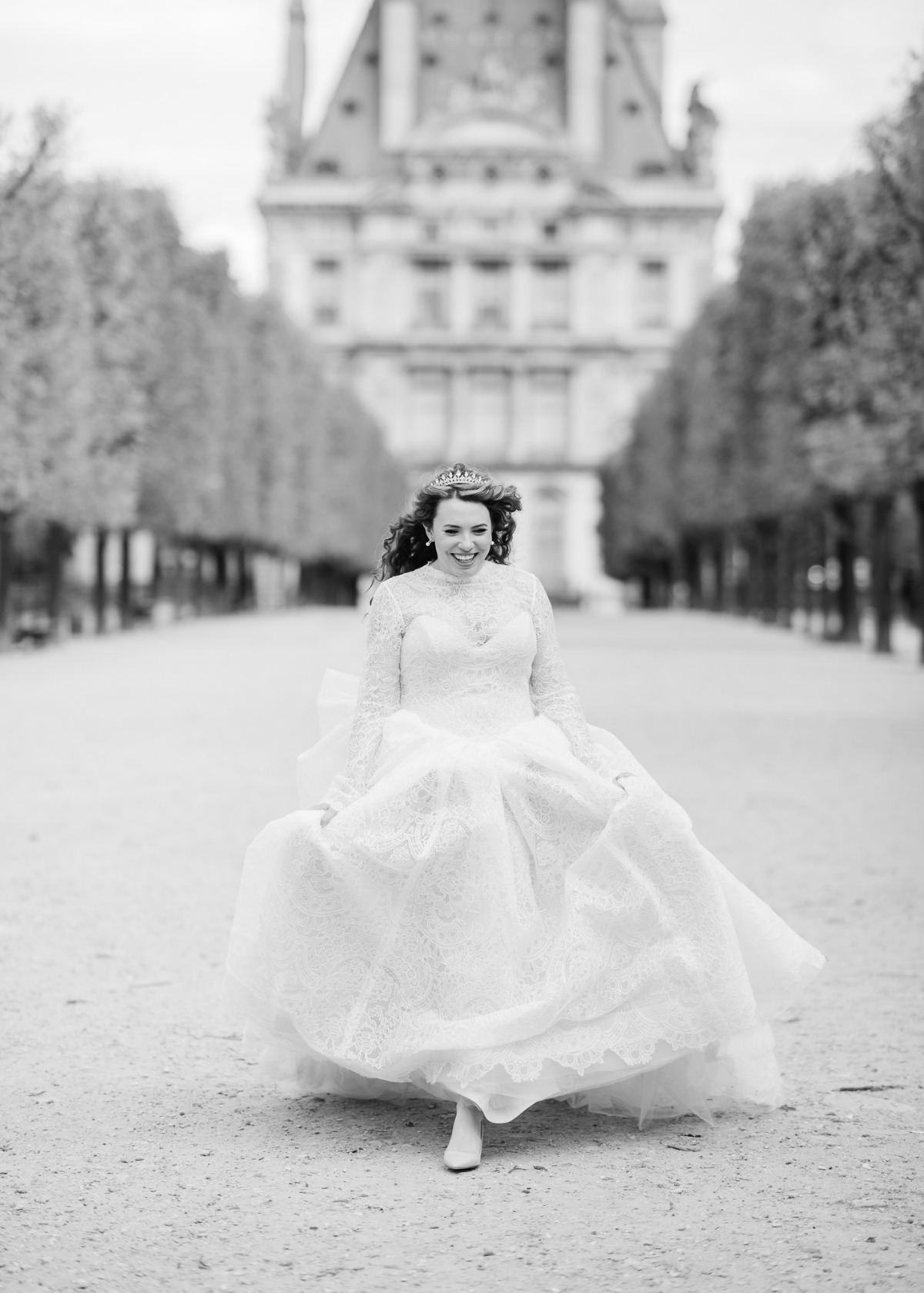 Bride runs joyfully in wedding dress near a famous building