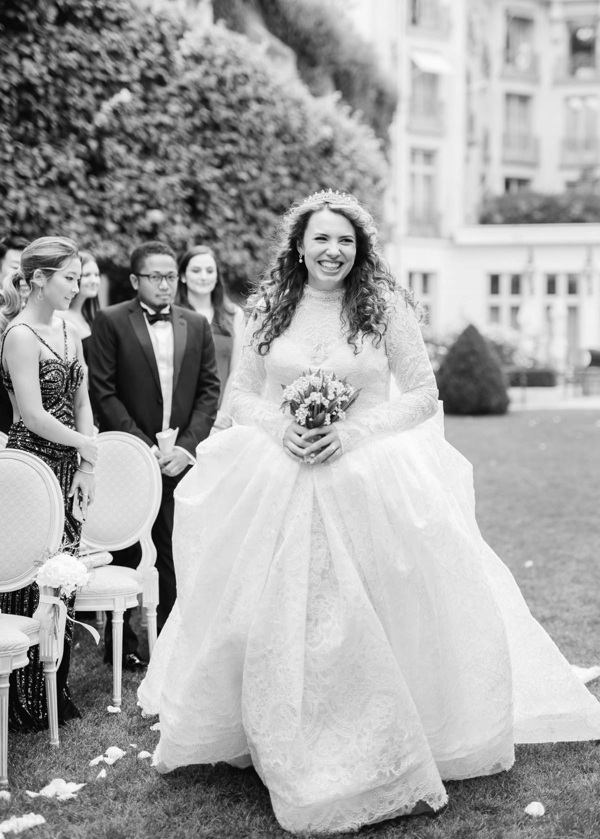 Smiling bride in a stunning wedding dress with bouquet, black and white photo