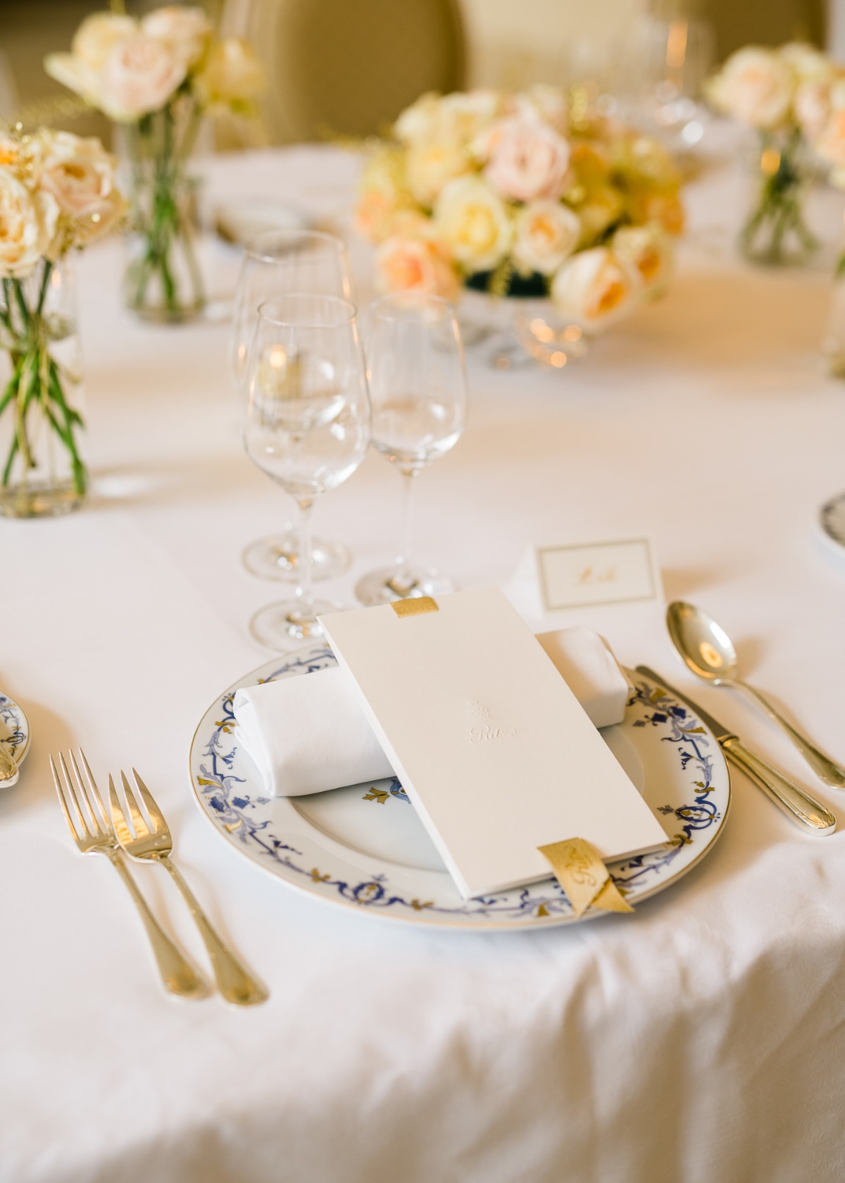 Elegant table setting with flowers, menu card, and gold silverware