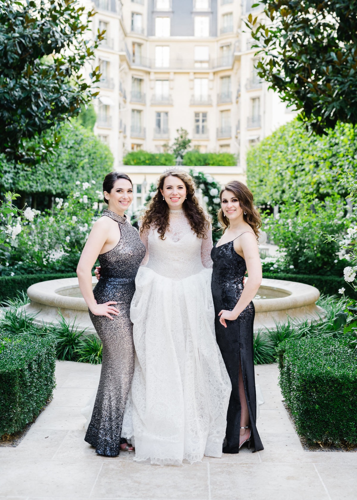 Bride with bridesmaids in sequined gowns in a garden