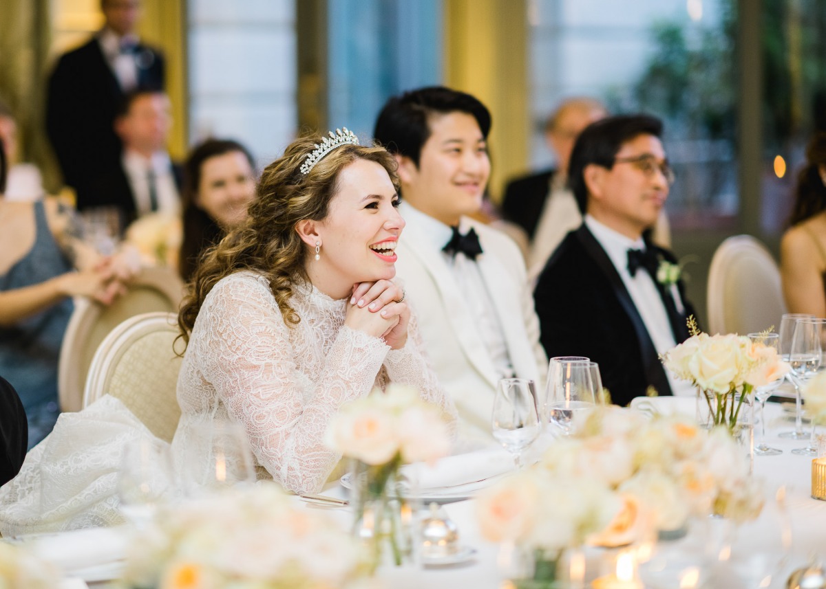 Bride laughing at the wedding reception with guests at the table