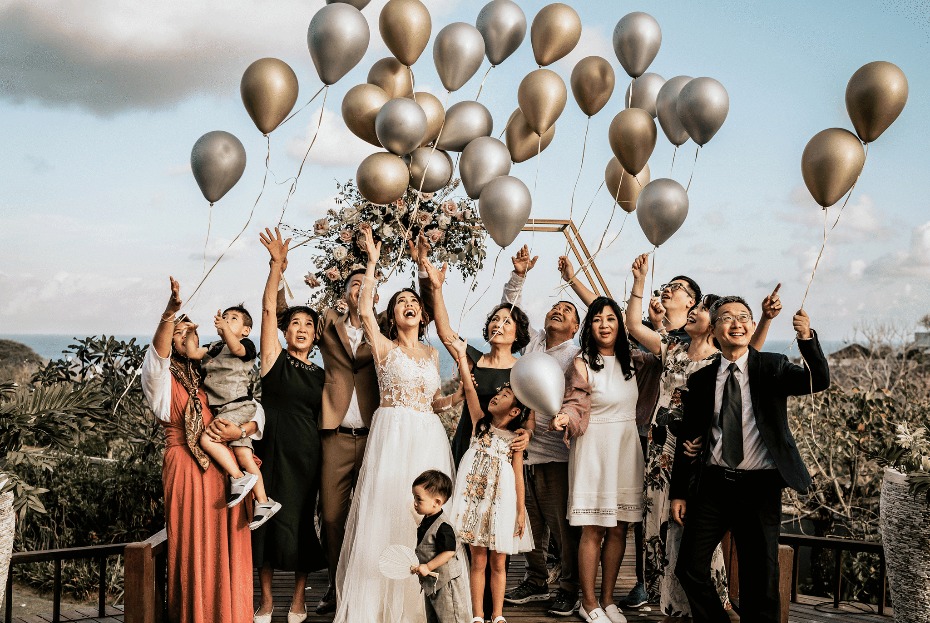 Joyful wedding party releases gold silver balloons skyward