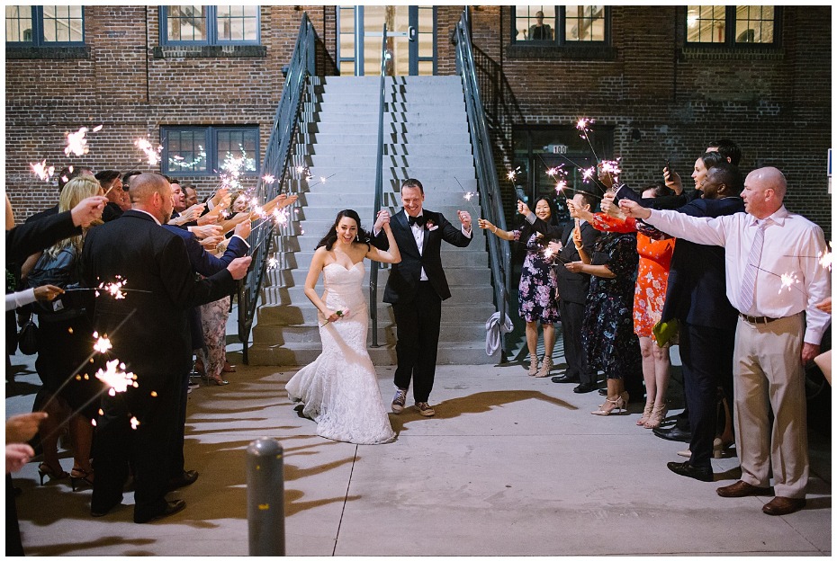 Newlyweds walk through sparkler exit with wedding guests