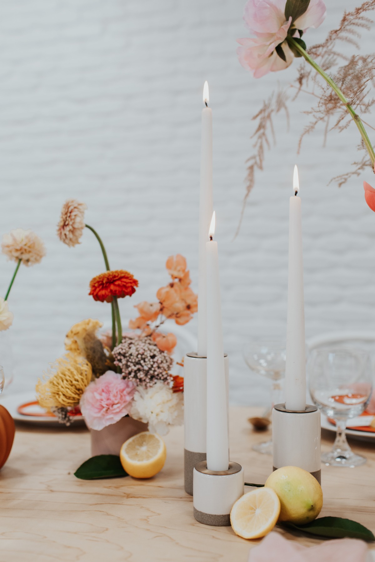 Elegant table setting with candles, flowers, and lemons
