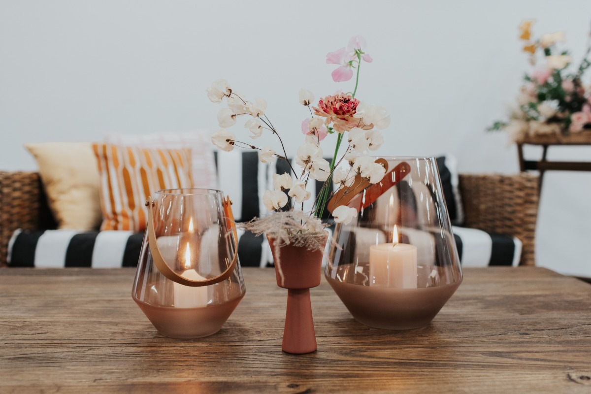 Candle lanterns and flowers on a wooden table decorates a living room