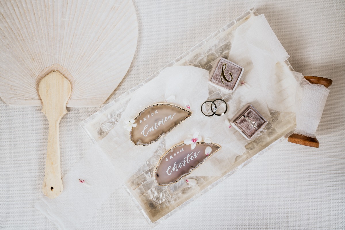 Elegant wedding details with rings, names and a fan