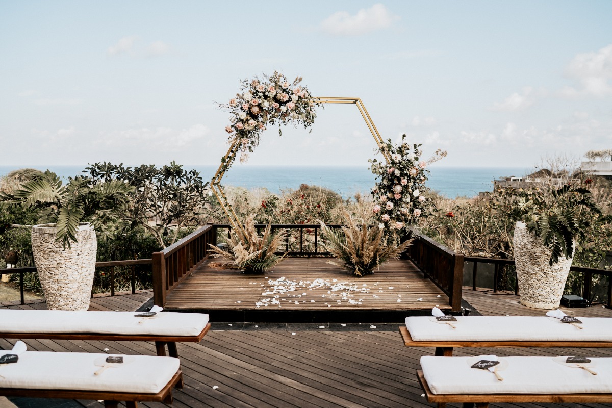 Wedding ceremony setup with ocean view and flower arch