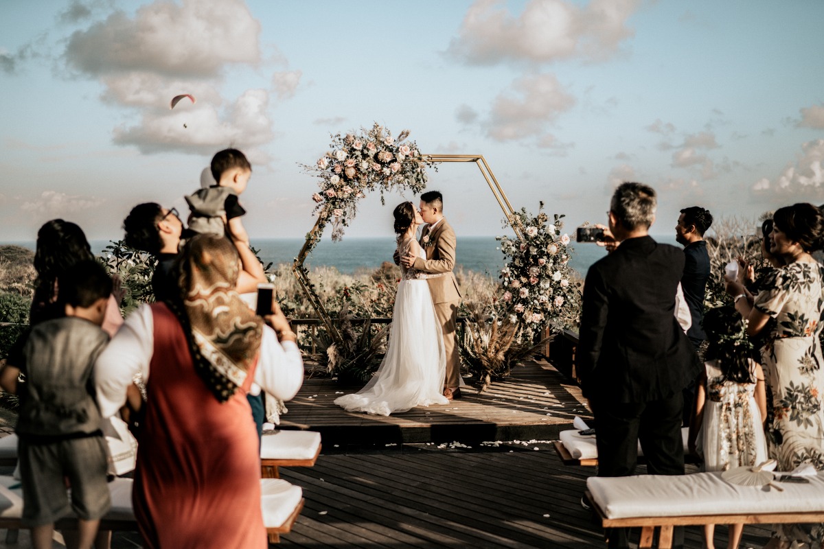 Bride and groom sharing a kiss during outdoor wedding ceremony