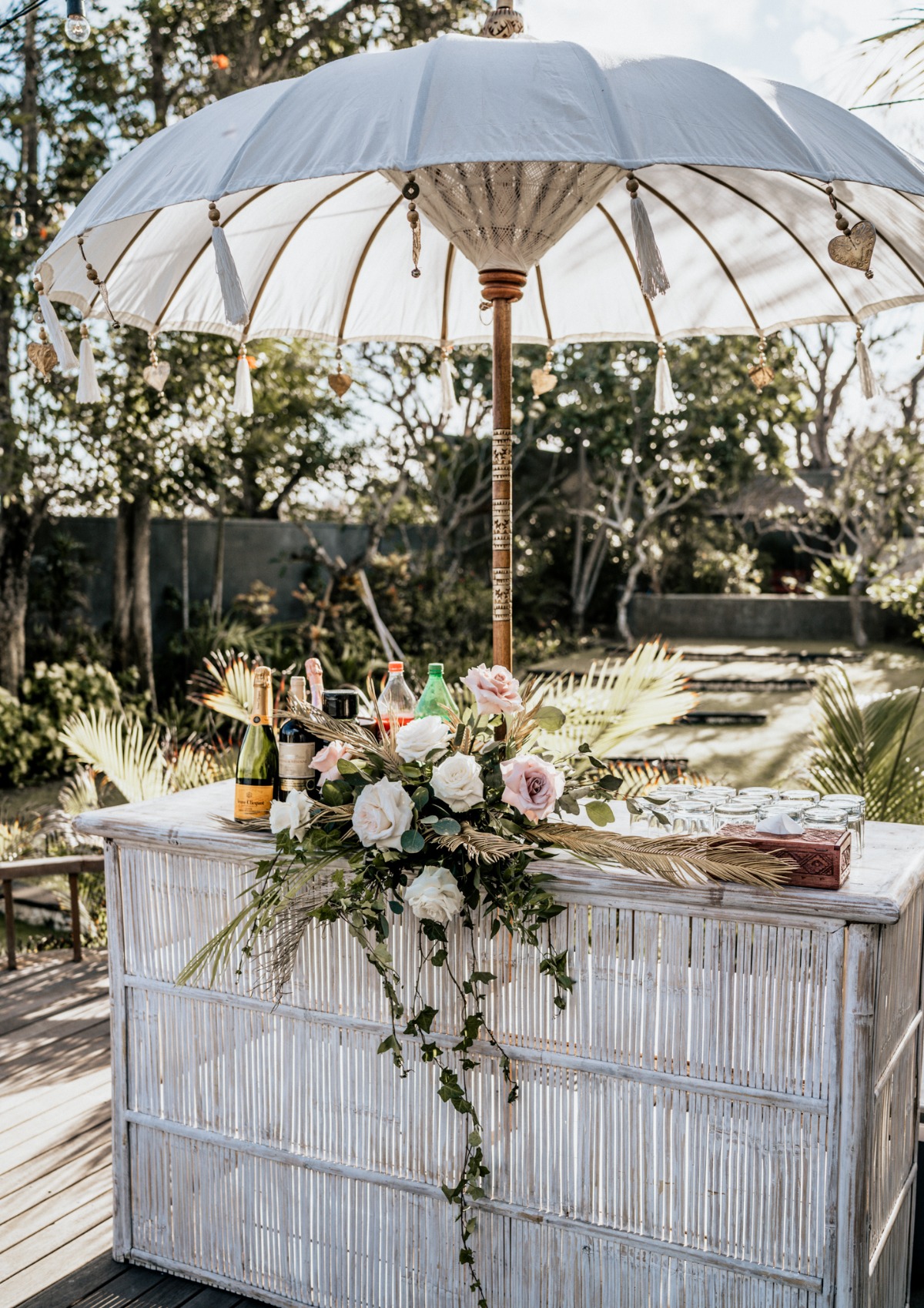 Outdoor bamboo bar with flowers under a white umbrella