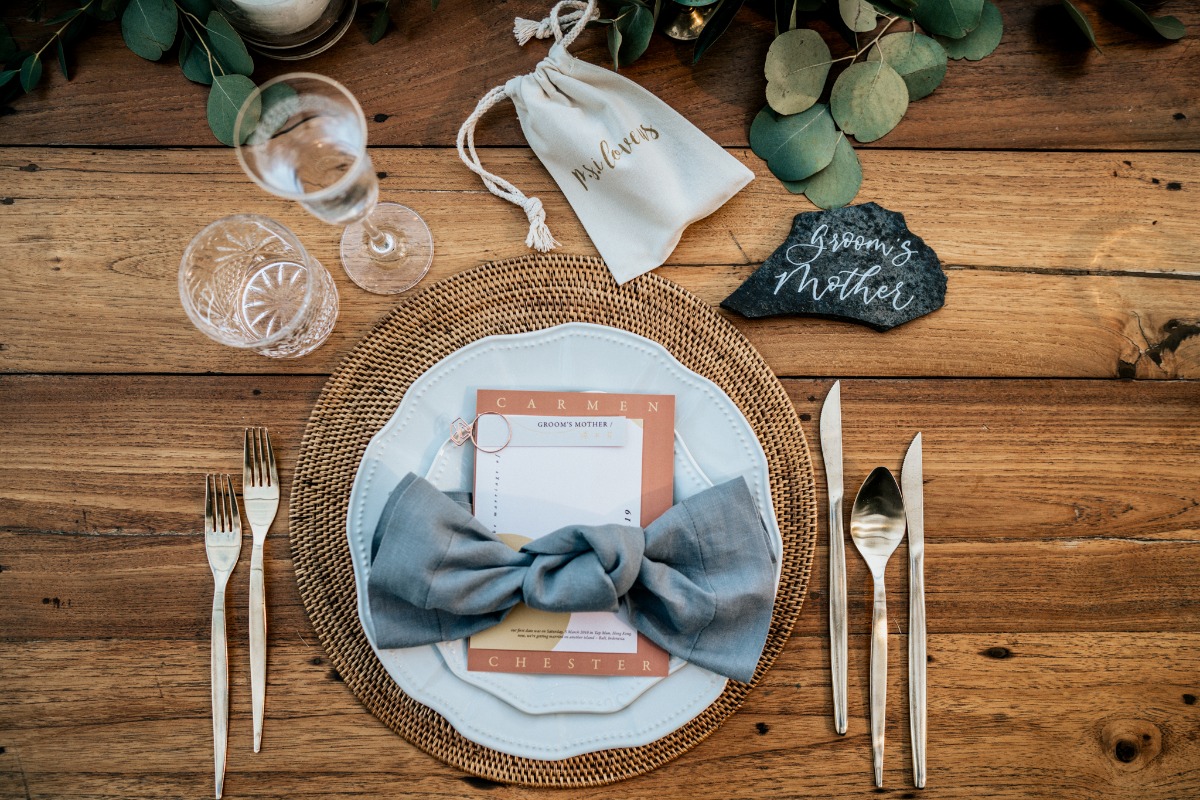 Elegant rustic wedding table setting with blue bow napkin