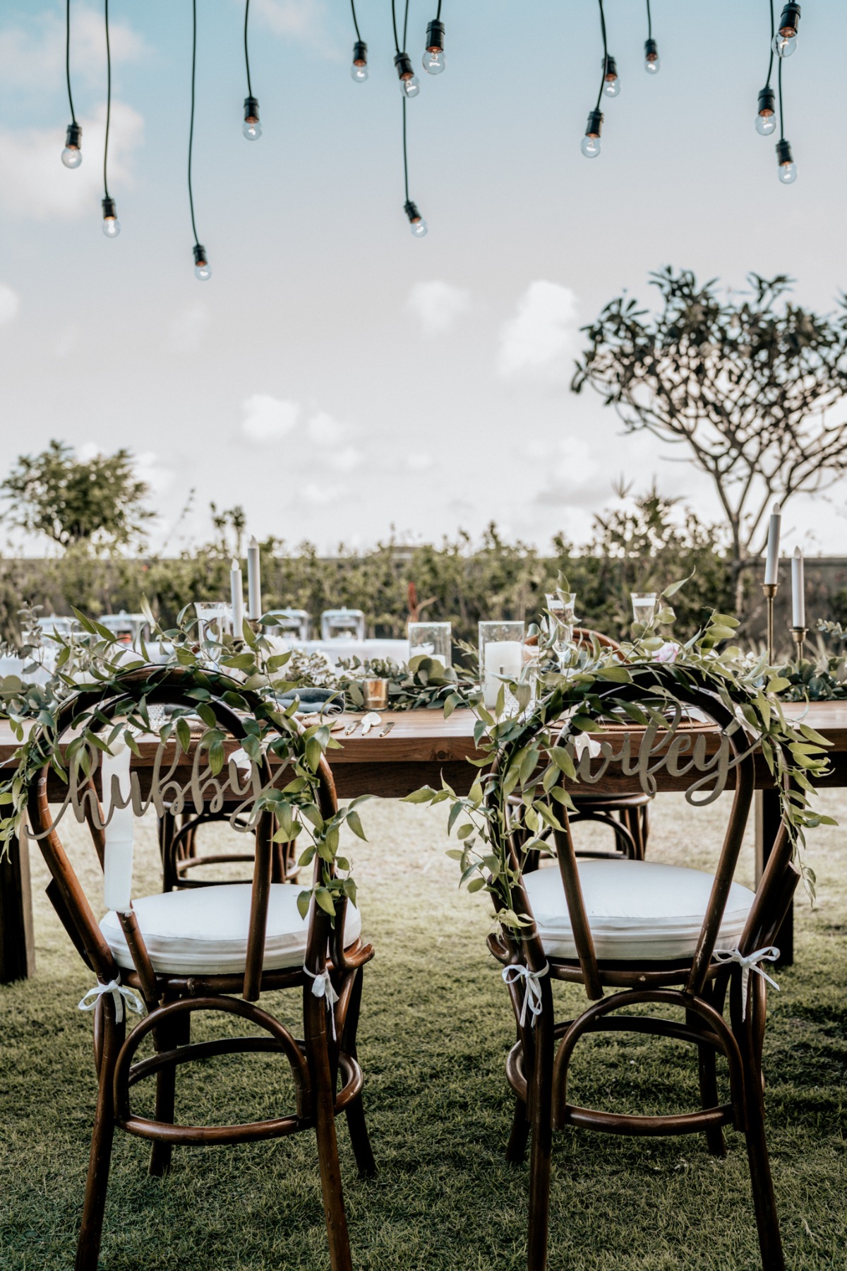 Hubby and Wifey chairs decorated for outdoor wedding