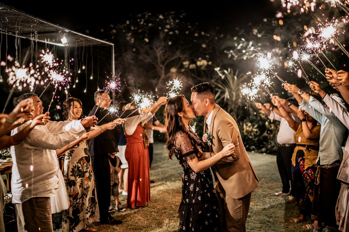 Couple kisses under a bright sparkler exit at night