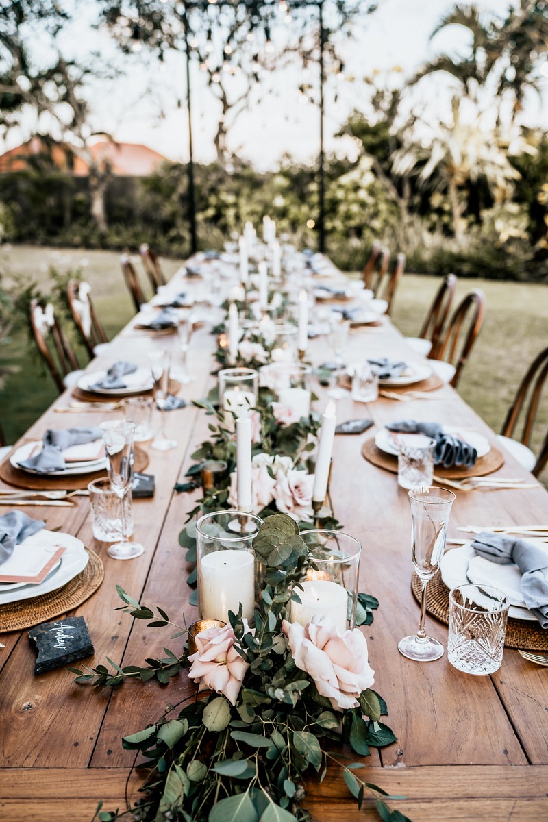 Rustic outdoor table setting with candles and flowers