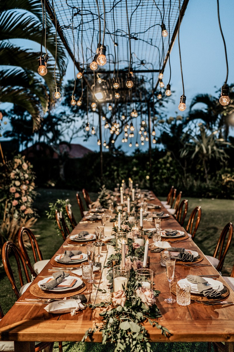 Elegant outdoor wedding table lit by hanging lights