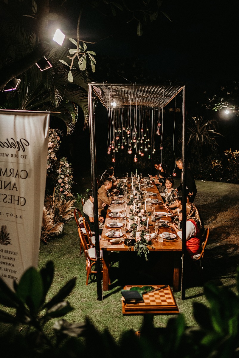 Night wedding dinner under romantic hanging light bulbs