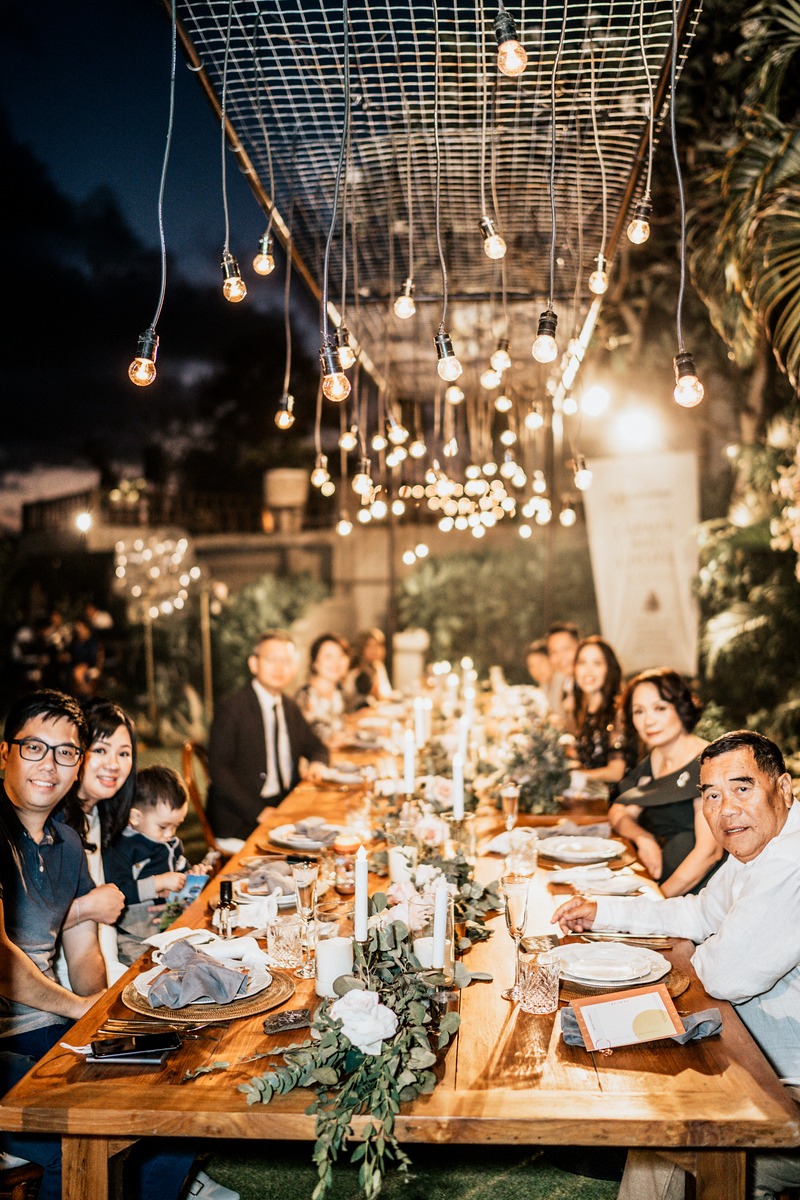 Warmly lit outdoor dinner party with happy guests seated
