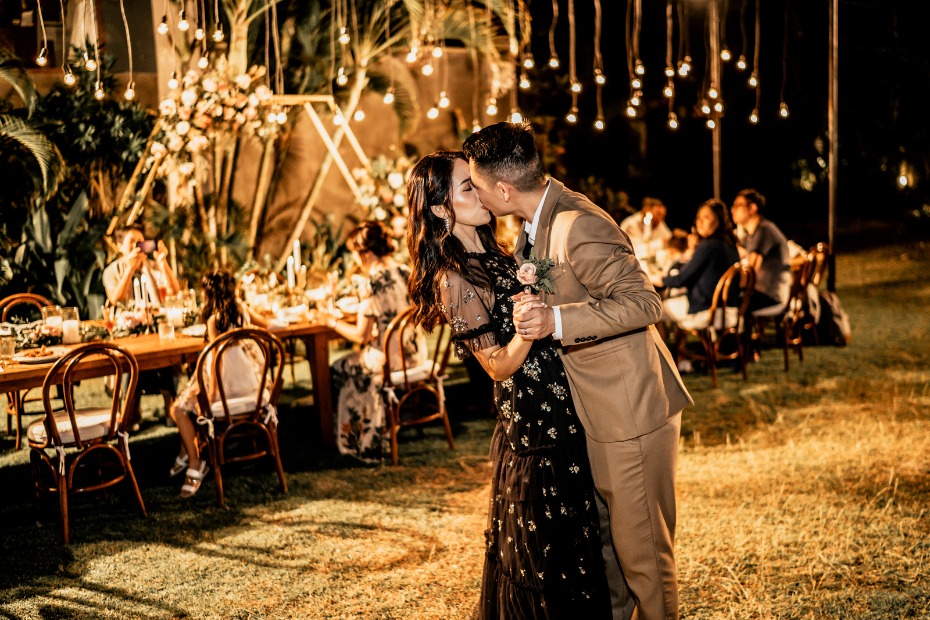 Couple kisses while dancing at outdoor night reception