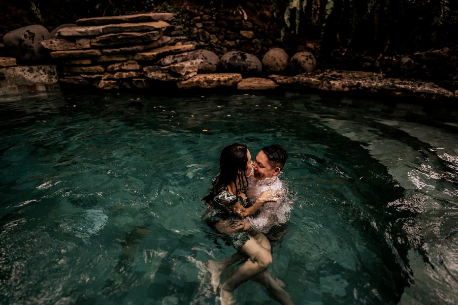 Couple kissing in a serene pool of water, intimate moment