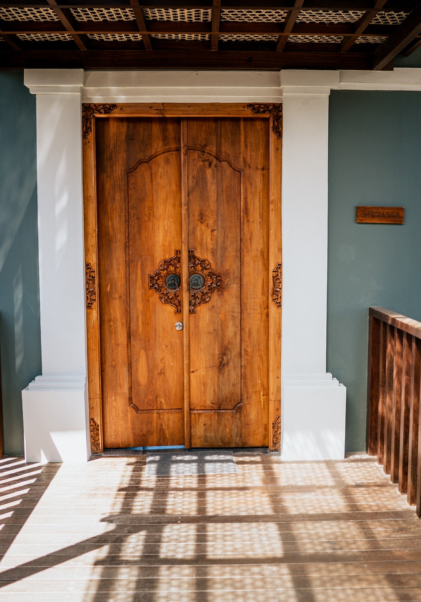 Ornate wooden door with detailed carvings and a bright surrounding