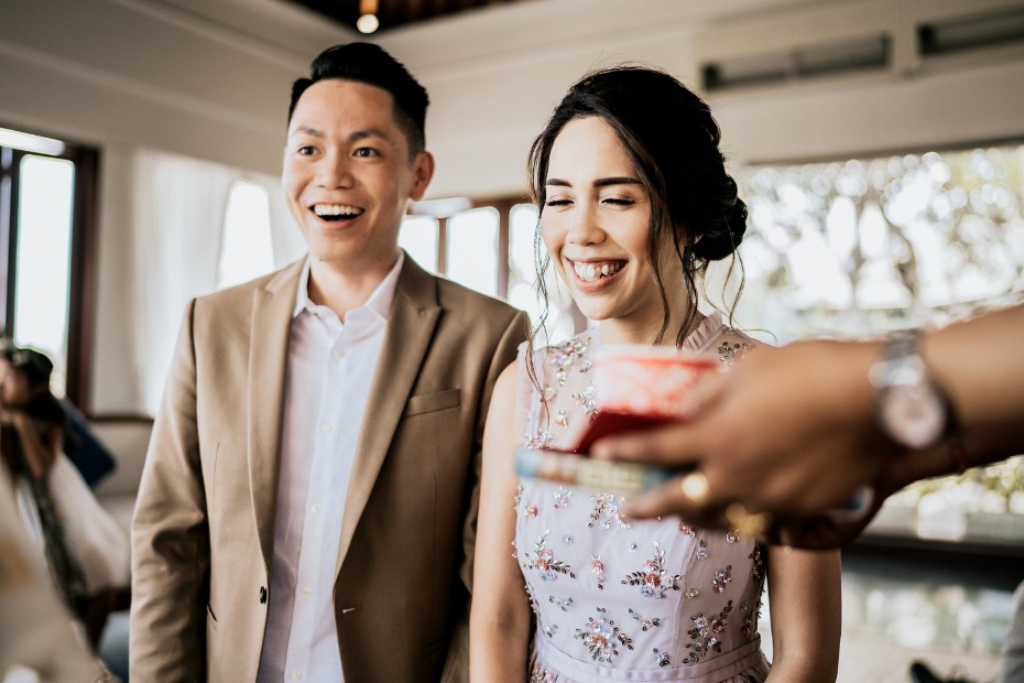 Happy couple smiles receiving a gift at a wedding ceremony