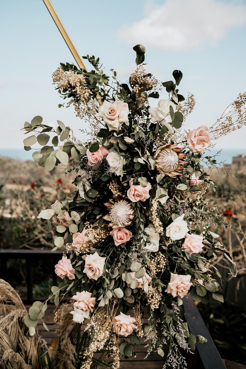 Wedding flower arrangement with roses and greenery outdoors