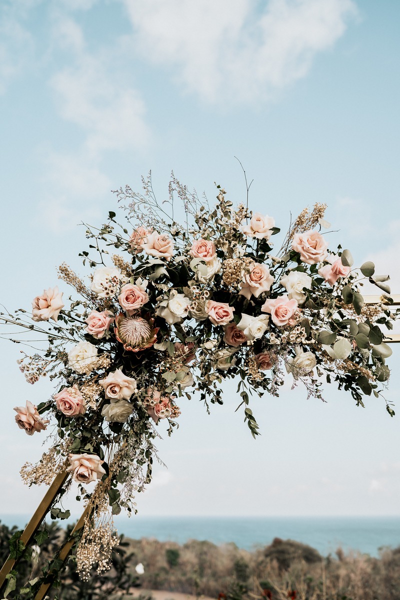 Elegant floral arch with roses for a romantic outdoor wedding ceremony