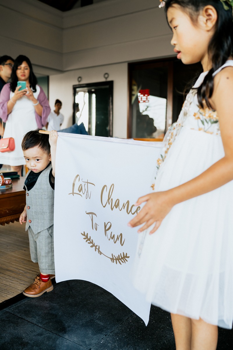 Two kids holding Last Chance To Run sign at a wedding