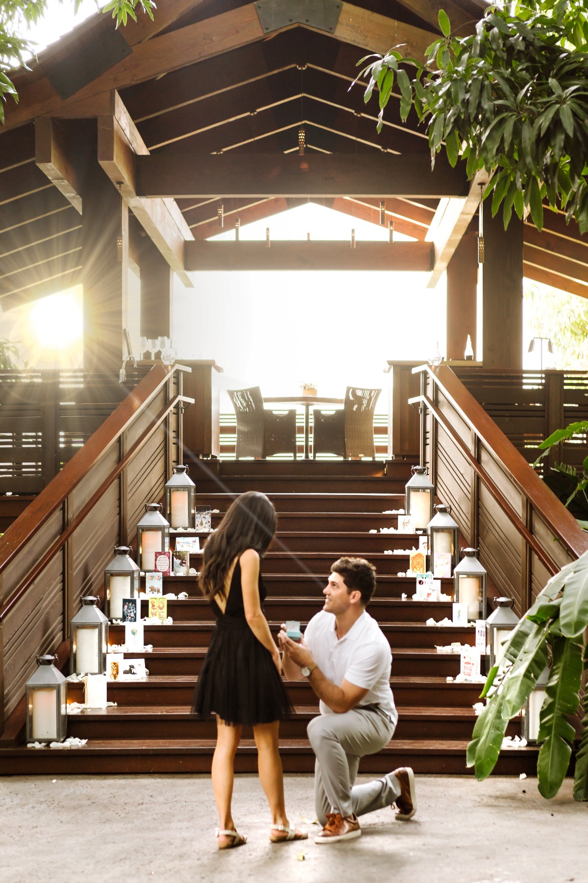 Man proposes to woman on decorated wooden staircase