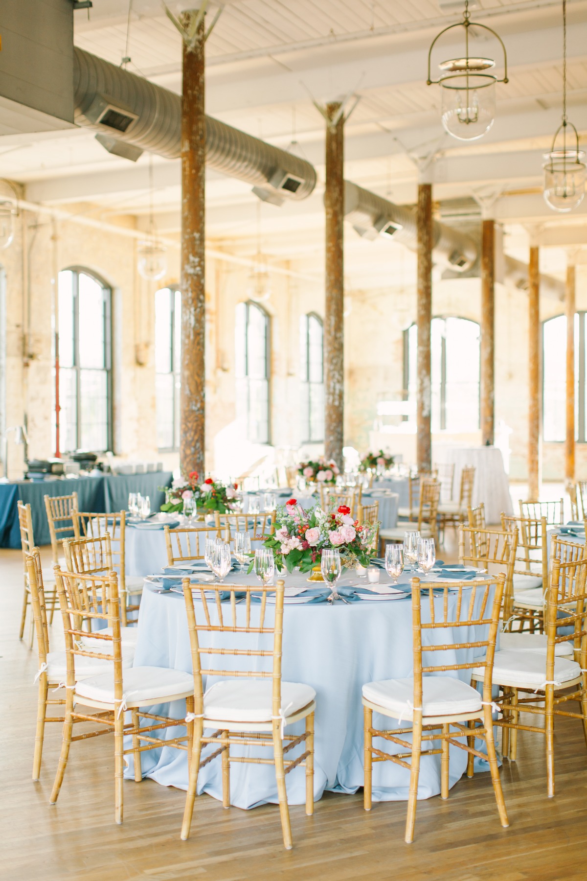 Elegant wedding reception with blue tablecloths and gold chairs