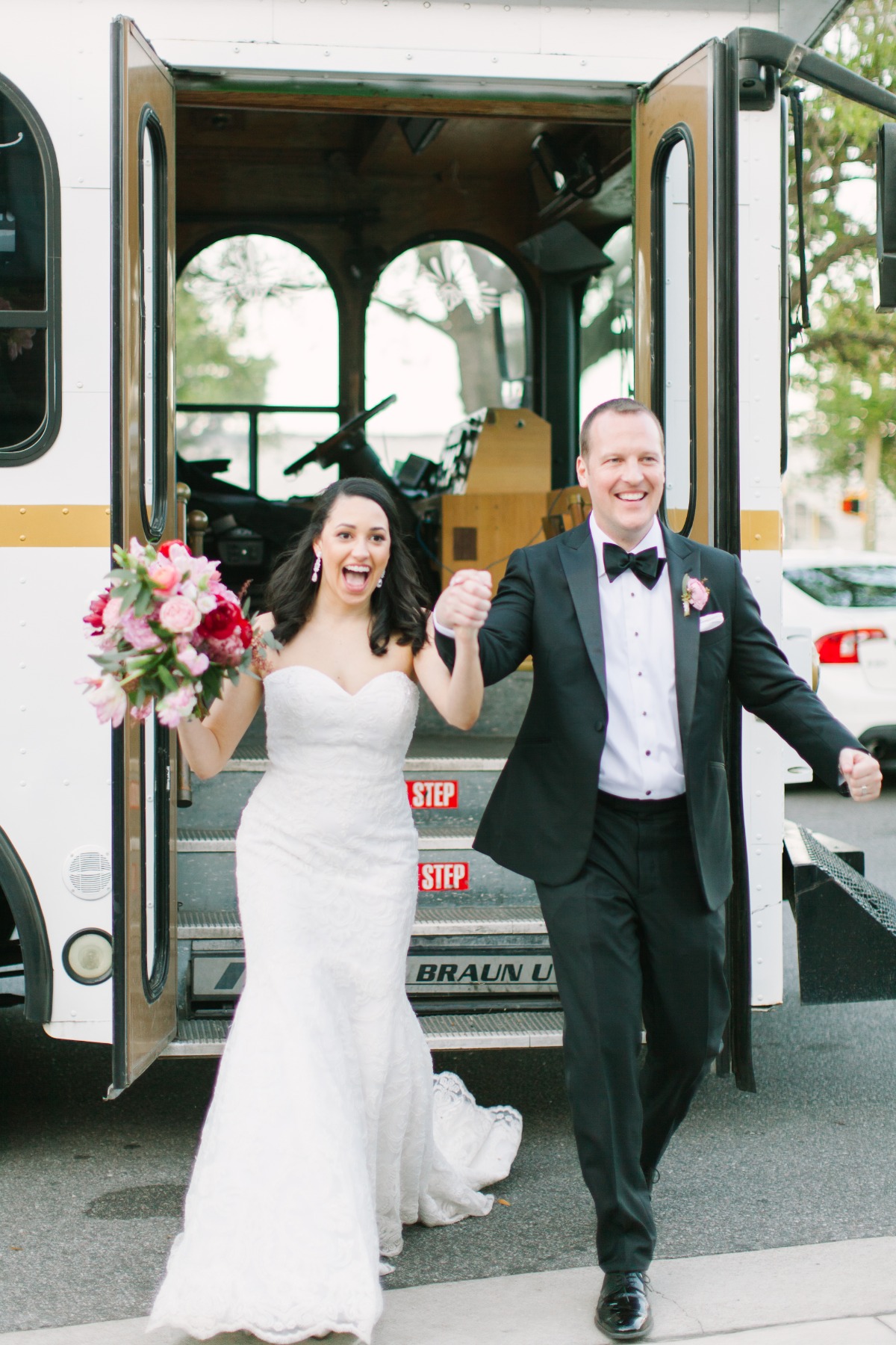 Newlyweds exiting a wedding trolley with joyful expressions