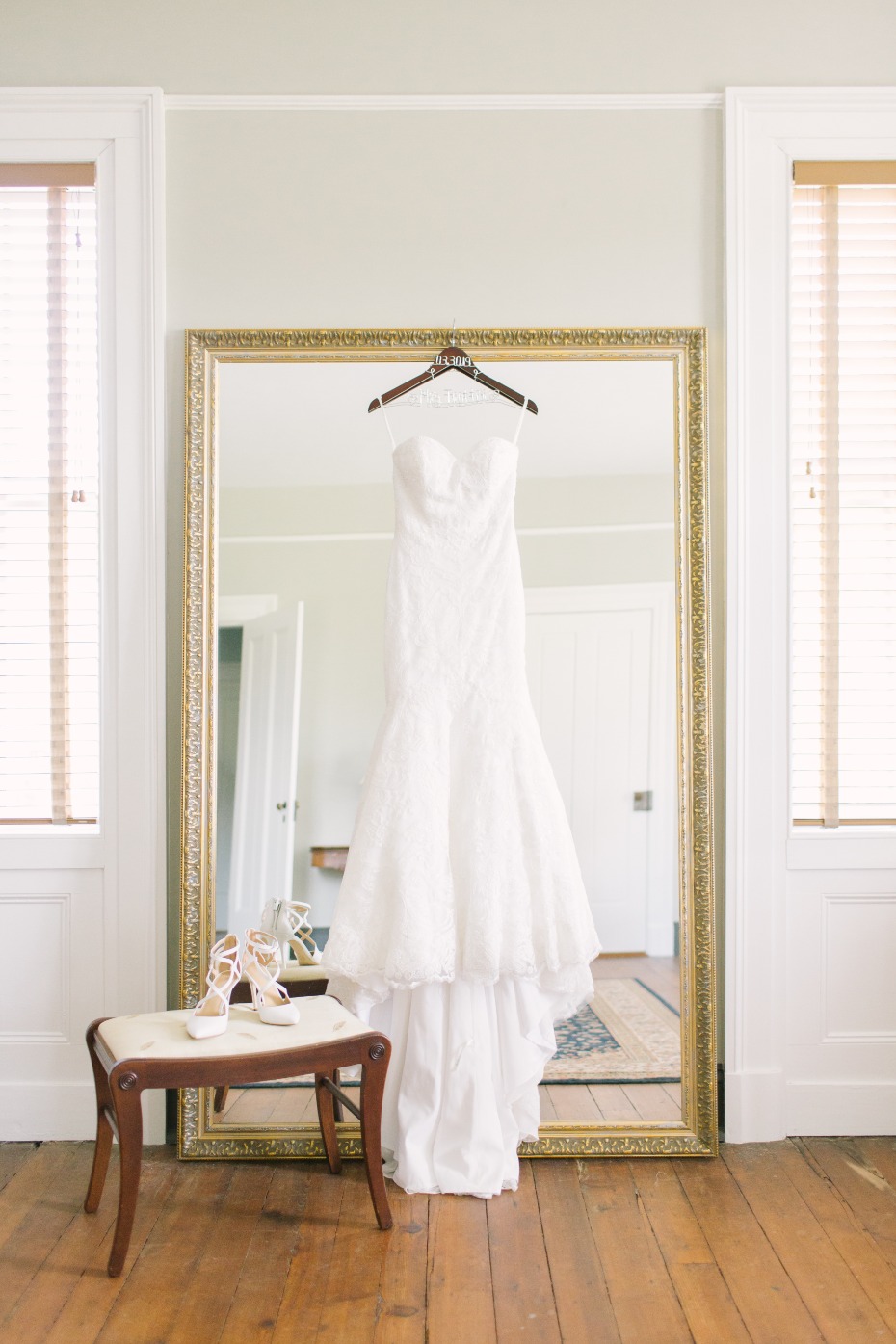Elegant wedding dress and shoes near a large mirror