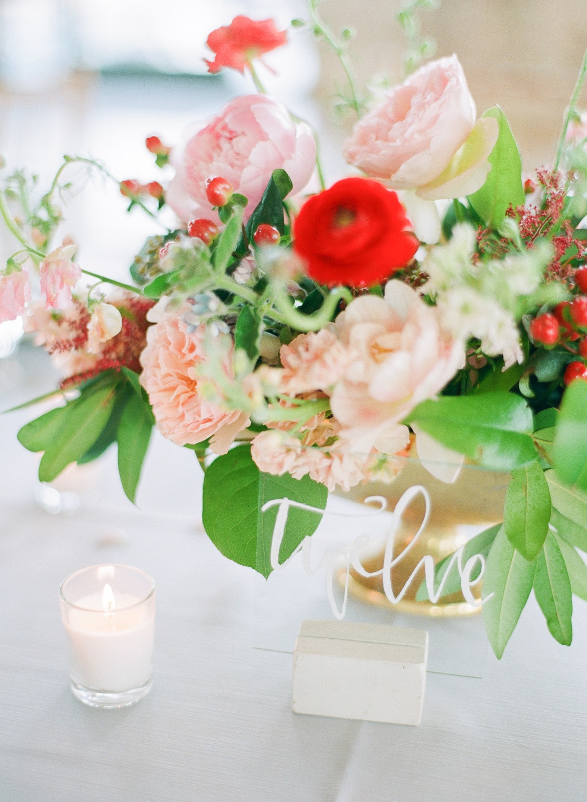 Elegant floral centerpiece with table number five and candle