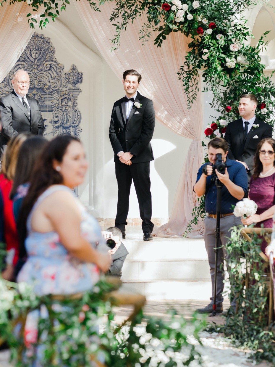 Groom awaits bride at a beautiful outdoor wedding venue