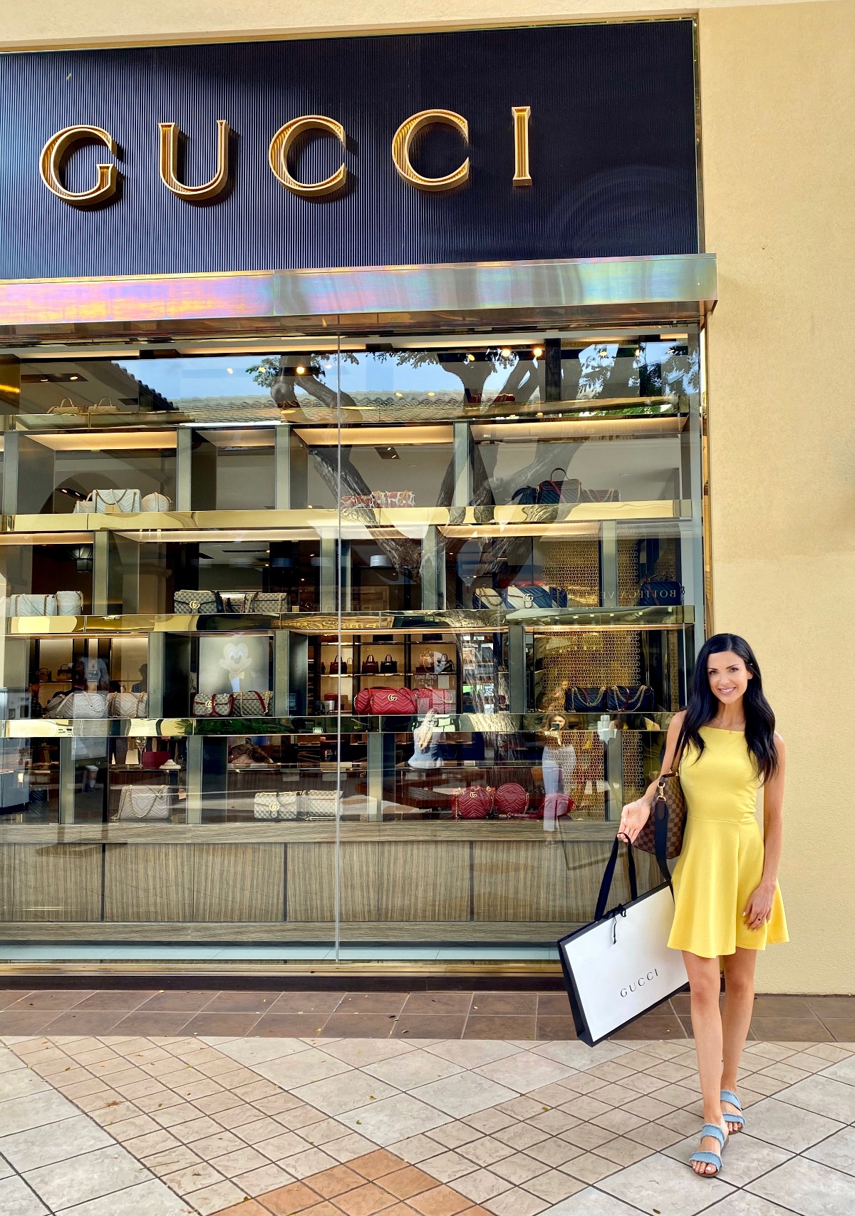 Woman shops at Gucci store with luxury handbag