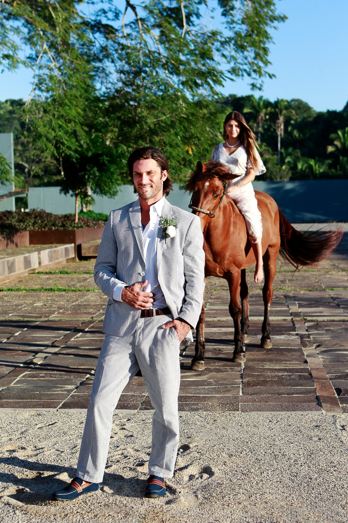 Groom awaits for his bride as she arrives on horseback