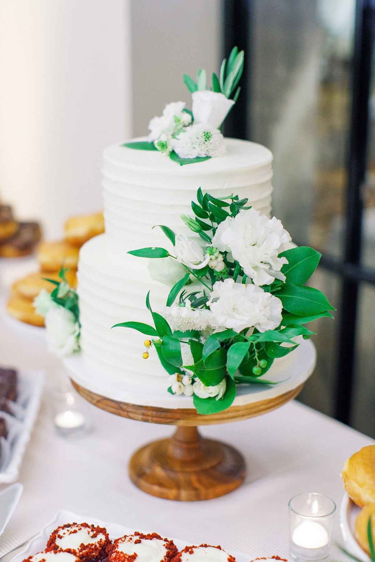 white wedding cake with green and white florals