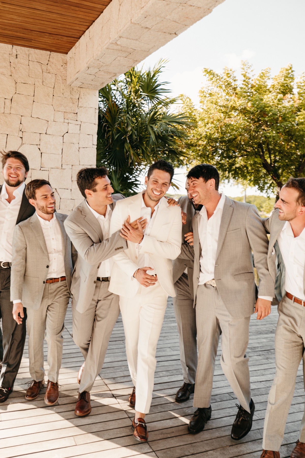 Groomsmen in linen suits with white shirts and brown shoes