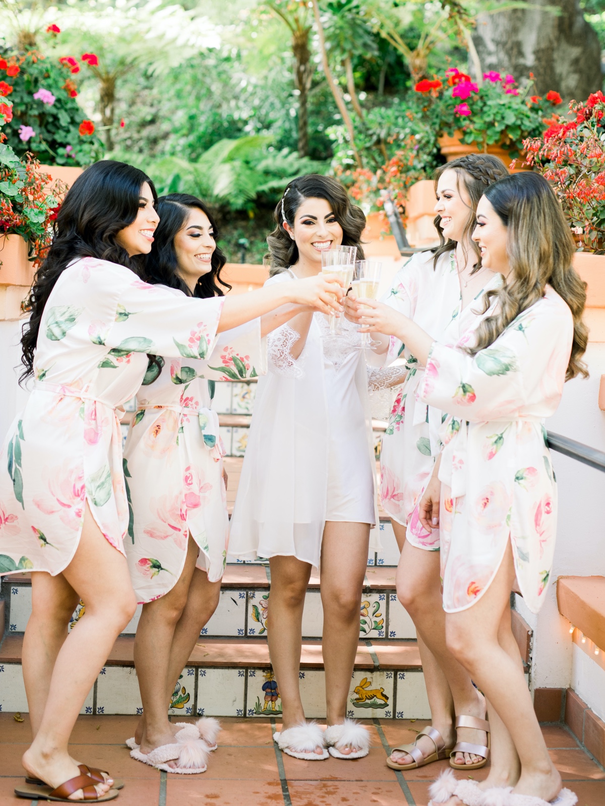 Bride and bridesmaids toasting with champagne outdoors