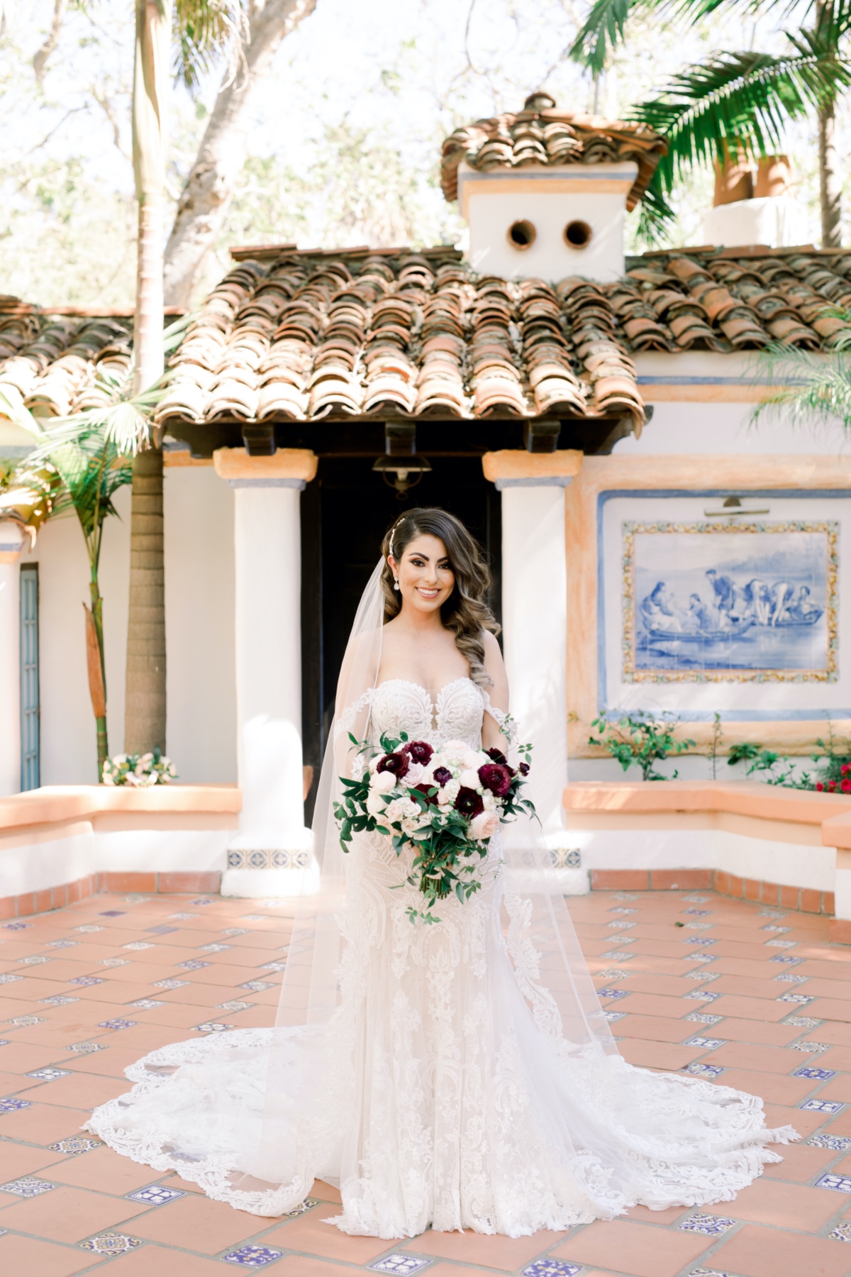 classic bride holding a burgundy and blush boquuet